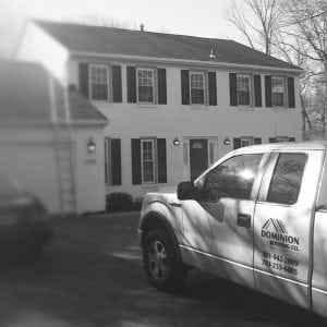 Dominion Roofing Co. truck parked in front of a house