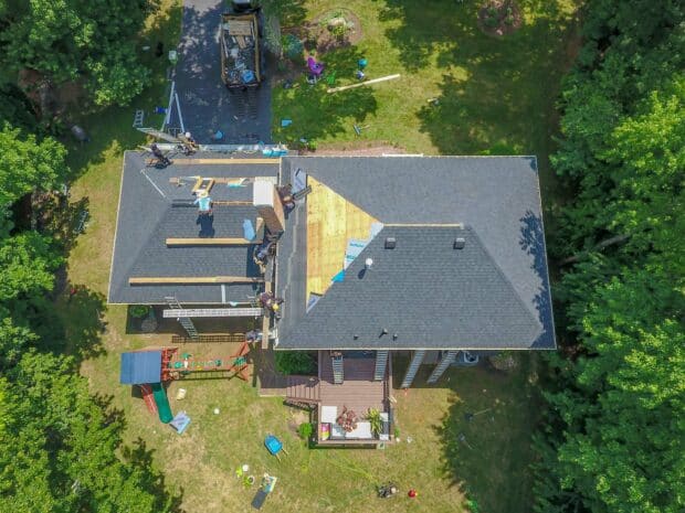 aerial view of roofers replacing shingles