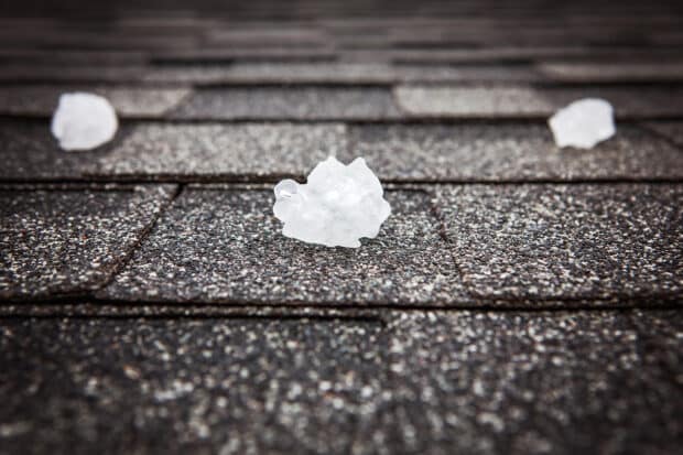 close up of large hail on roof shingles