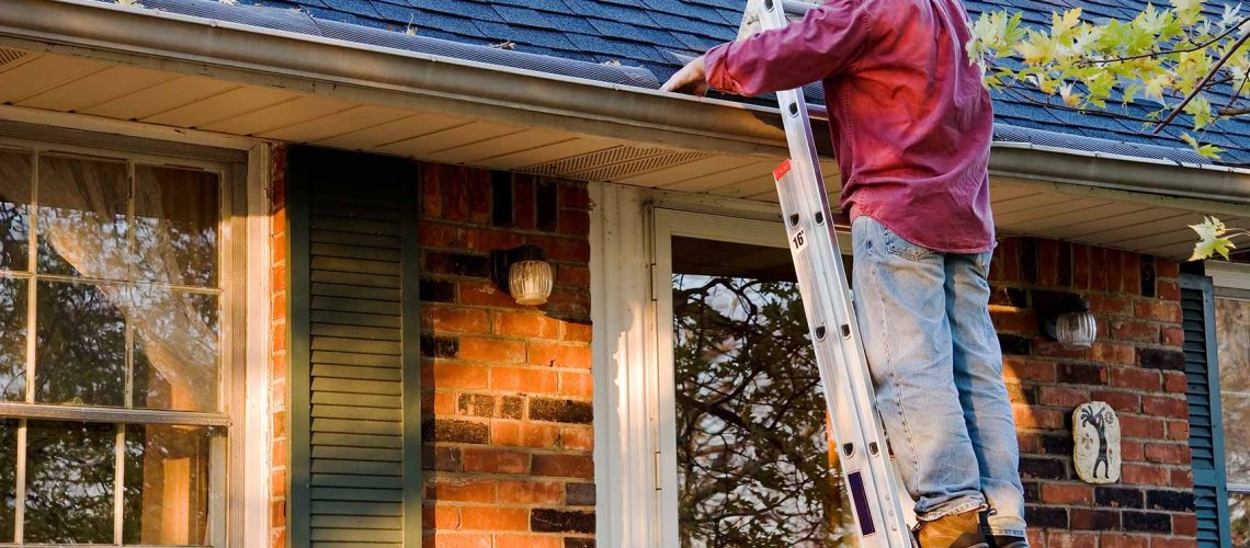 man cleaning gutters